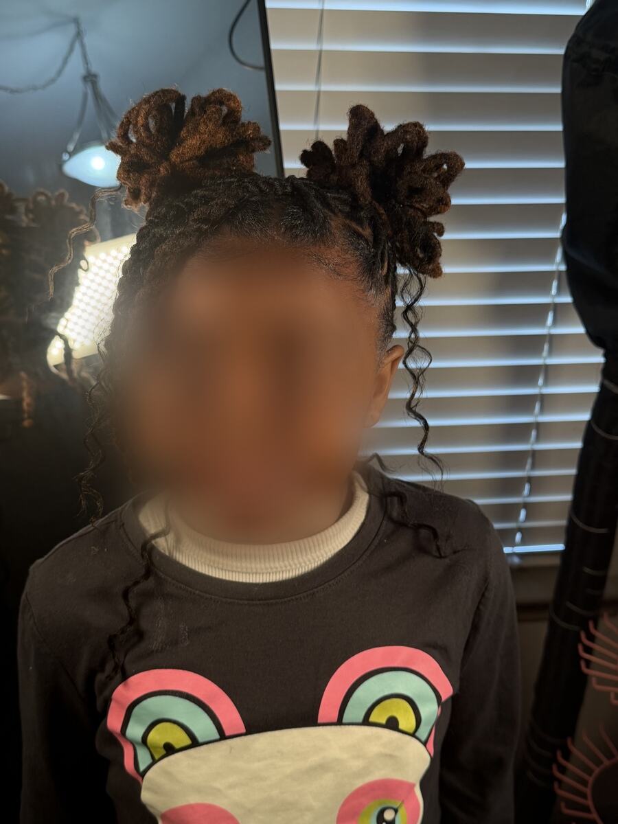 Child's loc style with two curled buns and curly ends, front view